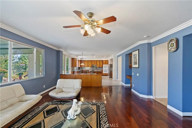 living room featuring a baseboard heating unit, dark wood-type flooring, ornamental molding, and ceiling fan