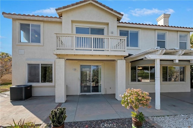 rear view of house featuring cooling unit, a balcony, a pergola, and a patio area