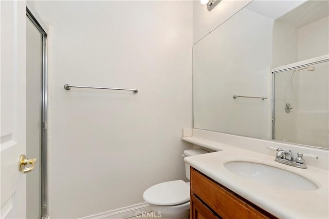 bathroom with vanity, a shower with shower door, and toilet