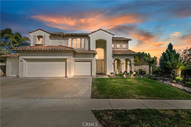 mediterranean / spanish-style house with a yard and a garage