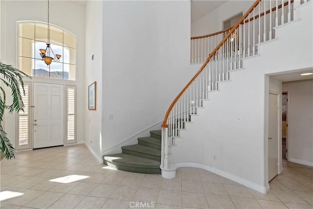 foyer with a towering ceiling and light tile patterned floors