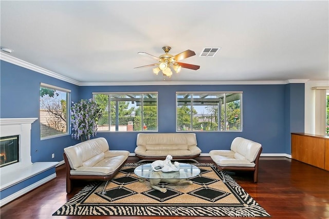 living room with crown molding, a wealth of natural light, and dark hardwood / wood-style flooring