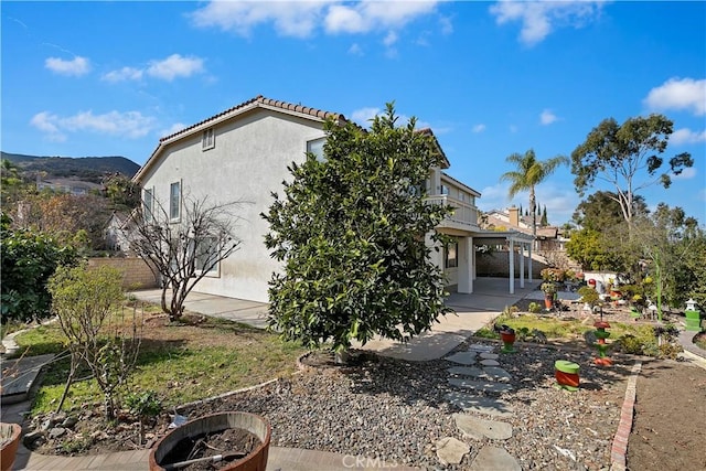 view of property exterior featuring a patio and a fire pit