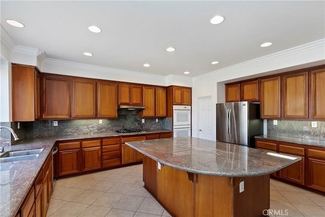 kitchen featuring a breakfast bar, sink, stone countertops, a center island, and stainless steel appliances