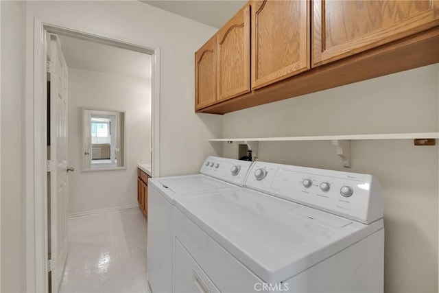 washroom with cabinets and washer and dryer