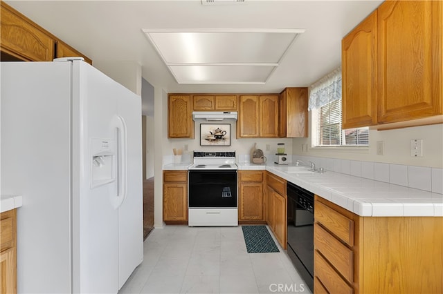 kitchen with electric range oven, sink, black dishwasher, white refrigerator with ice dispenser, and tile counters