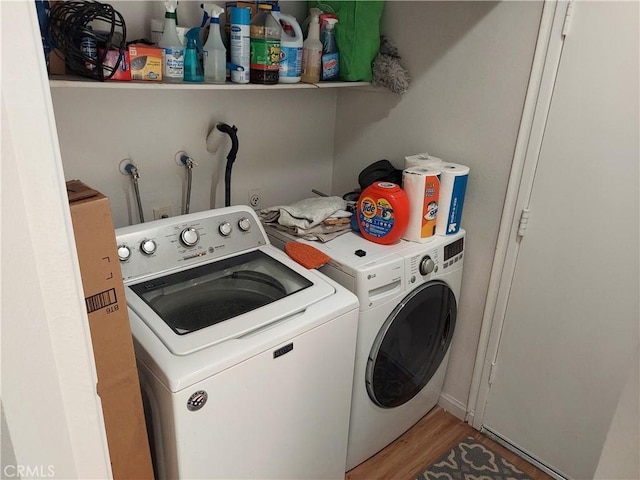 washroom featuring light wood-type flooring, laundry area, and separate washer and dryer