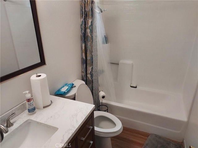 full bath featuring toilet, shower / bath combo, wood finished floors, and vanity