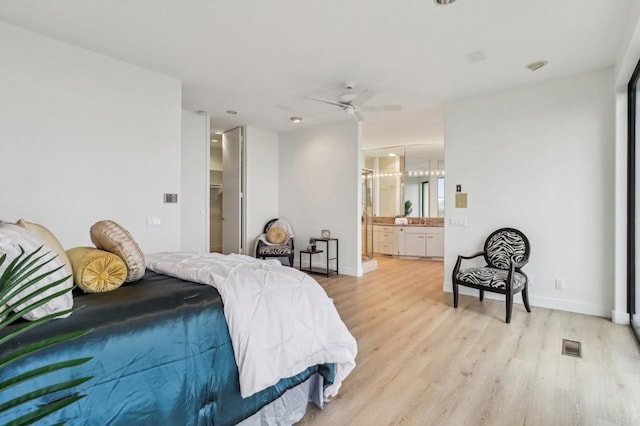 bedroom with ceiling fan, ensuite bathroom, and light hardwood / wood-style flooring