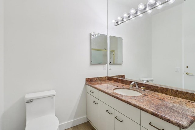 bathroom with vanity, wood-type flooring, and toilet