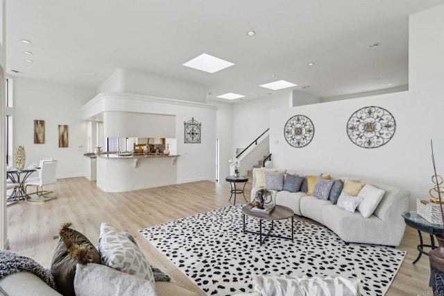 living room with a skylight and light hardwood / wood-style flooring