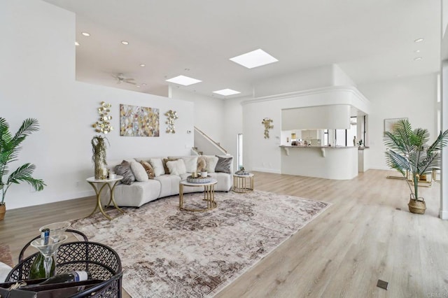 living room with ceiling fan and light hardwood / wood-style floors