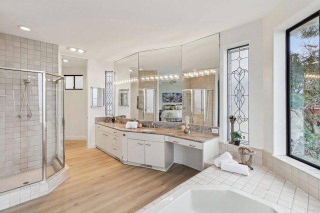 bathroom with hardwood / wood-style flooring, vanity, and independent shower and bath