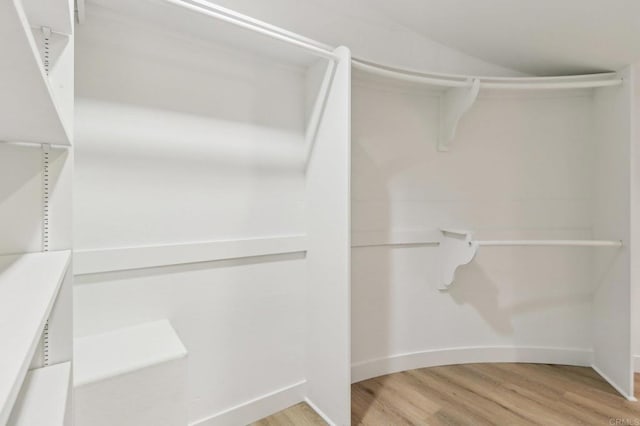 walk in closet with light hardwood / wood-style floors