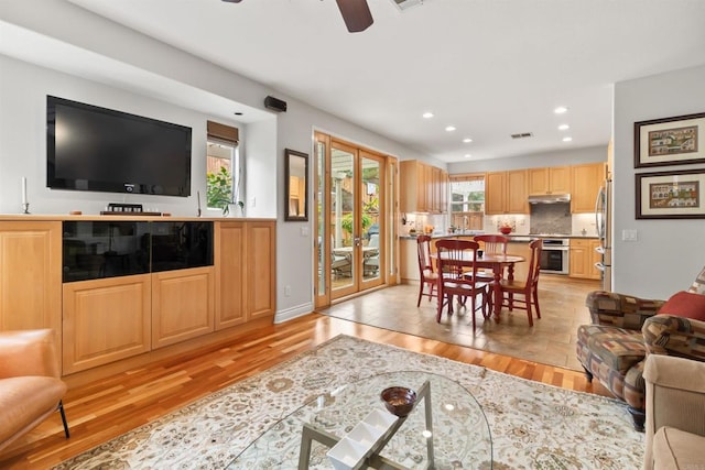 living room with a healthy amount of sunlight, light wood-style flooring, visible vents, and recessed lighting