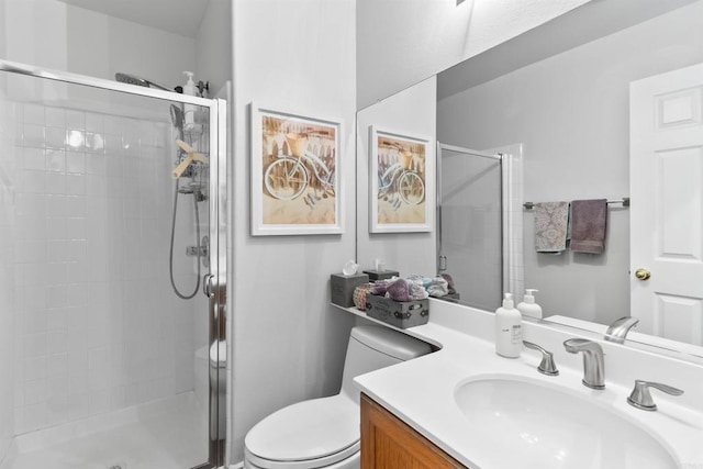 bathroom with a stall shower, vanity, and toilet