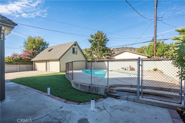 view of pool with a garage, an outdoor structure, and a lawn