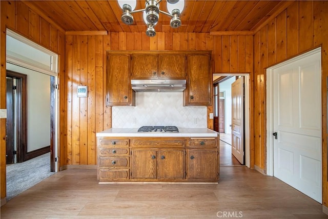 kitchen with backsplash, a chandelier, stainless steel gas cooktop, and wooden ceiling