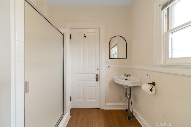 bathroom featuring hardwood / wood-style flooring and a shower with shower door