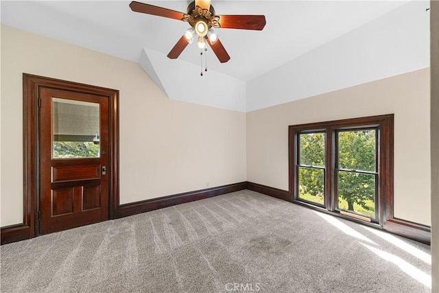 carpeted empty room with vaulted ceiling and ceiling fan