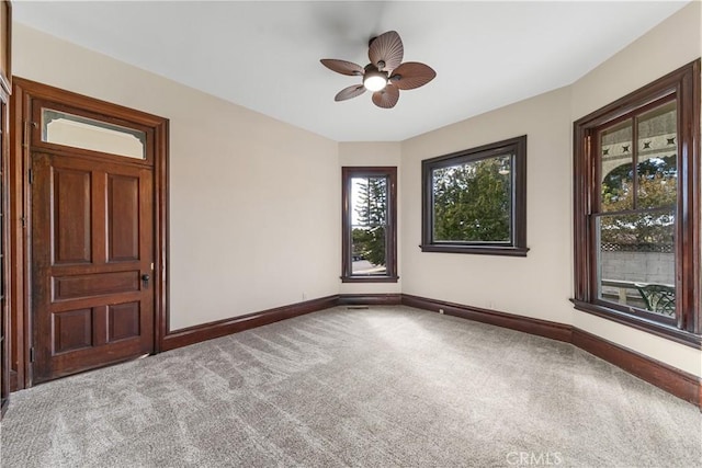 carpeted spare room with ceiling fan