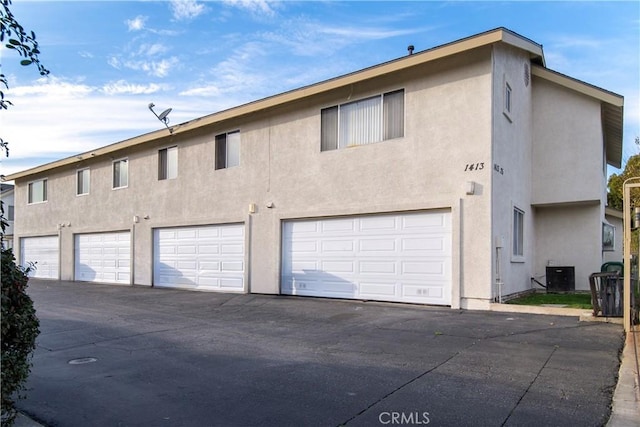 exterior space featuring cooling unit and a garage