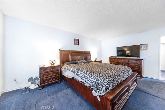 bedroom with dark carpet and a textured ceiling