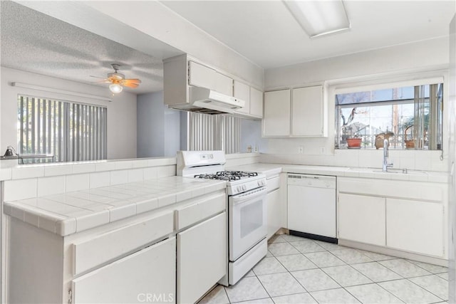 kitchen featuring white cabinetry, white appliances, tile countertops, and plenty of natural light