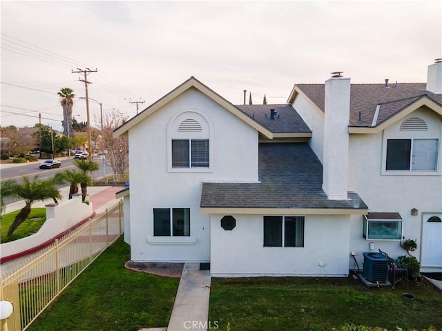 view of front of house featuring a front lawn and central air condition unit