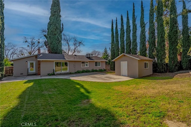 back of property featuring a storage shed, a lawn, and a patio