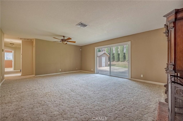 unfurnished living room with plenty of natural light, a textured ceiling, and carpet