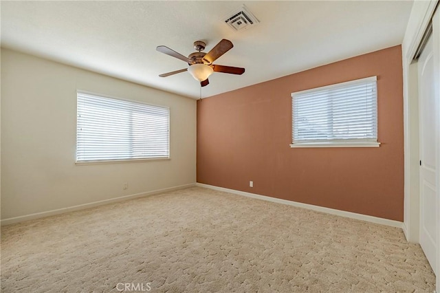 carpeted spare room with ceiling fan