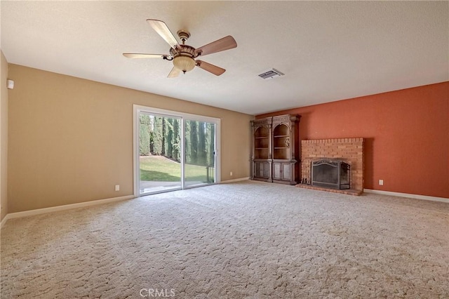 unfurnished living room featuring a brick fireplace, ceiling fan, and carpet flooring