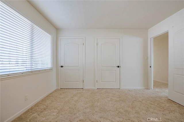 unfurnished bedroom with light colored carpet