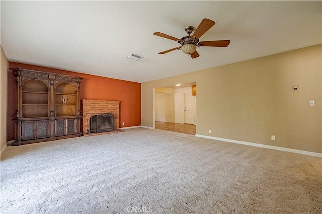 unfurnished living room with a brick fireplace, carpet floors, and ceiling fan