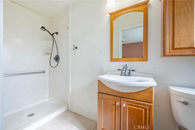 bathroom with tile patterned flooring, vanity, a shower, and toilet