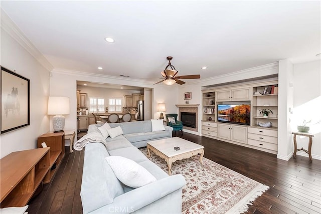 living room featuring dark wood-type flooring, ceiling fan, and ornamental molding