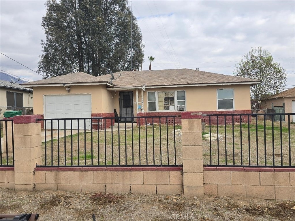 single story home featuring a garage and a front yard