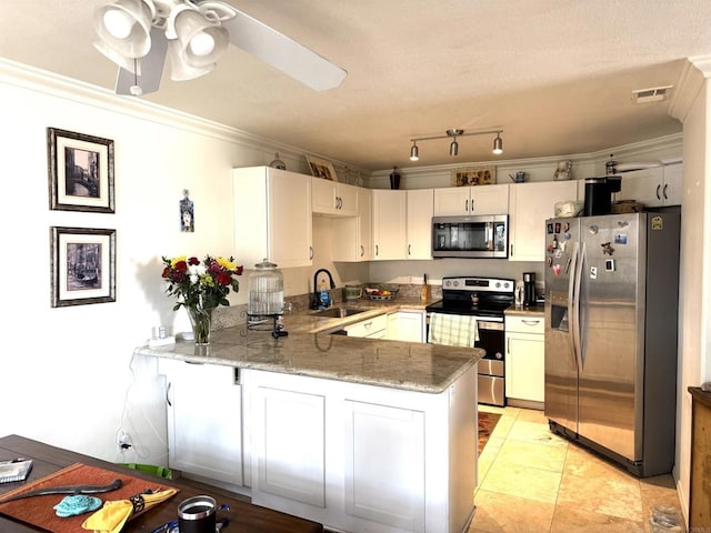 kitchen featuring a peninsula, white cabinets, stainless steel appliances, and a sink