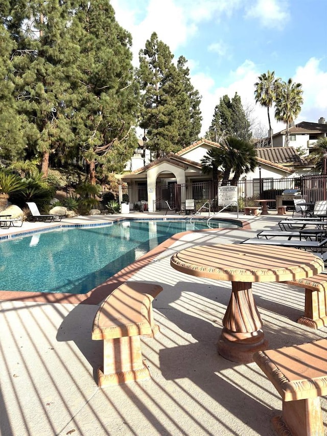 community pool featuring a patio area and fence