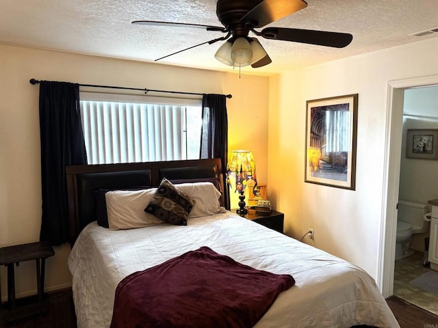 bedroom with a textured ceiling, ceiling fan, connected bathroom, and visible vents