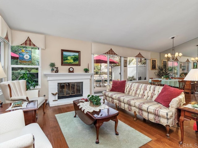 living room featuring lofted ceiling, wood-type flooring, and a chandelier