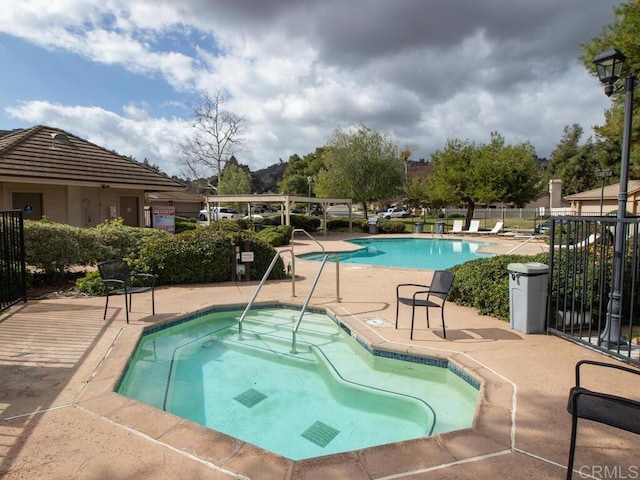 view of pool with a hot tub