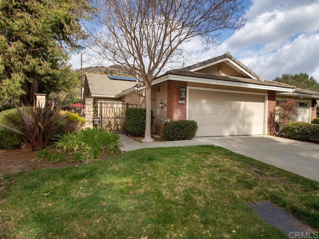 view of front of house with a garage, a front yard, and solar panels