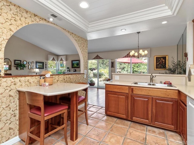 kitchen featuring crown molding, a tray ceiling, sink, and pendant lighting