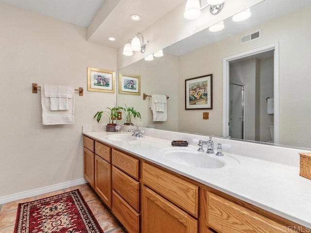 bathroom with tile patterned floors, vanity, toilet, and a shower with door