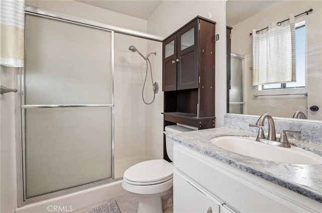 bathroom with vanity, toilet, tile patterned floors, and walk in shower