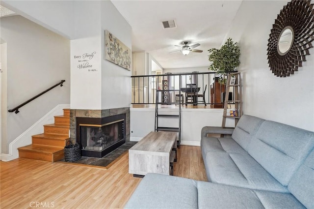 living room featuring hardwood / wood-style floors, a fireplace, and ceiling fan