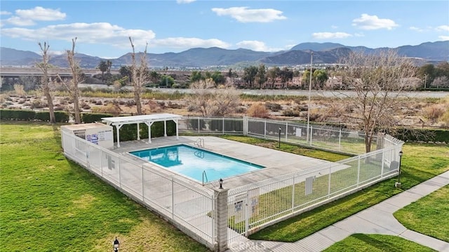 view of pool featuring a mountain view, a yard, a patio area, and a pergola