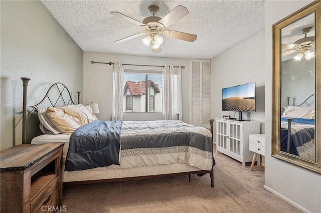 carpeted bedroom with ceiling fan and a textured ceiling